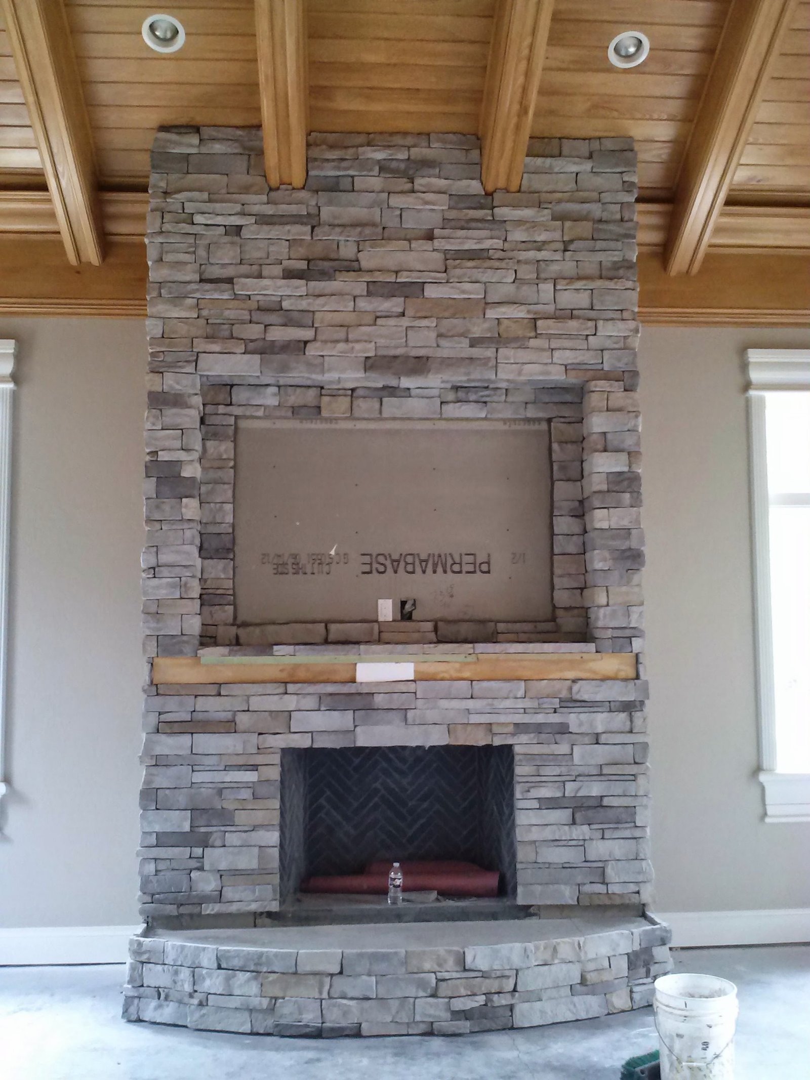Custom stone-covered outdoor fireplace built by Grand Line Renovations